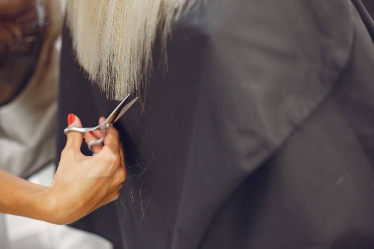 Hairdresser cut hair her client in a hair salon