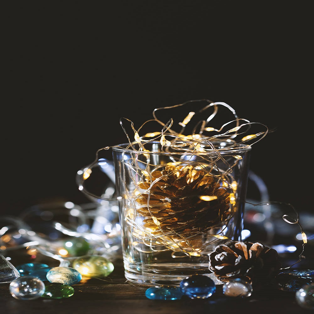 Glowing Christmas Lights and golden pine cone in a glass jar,Chr