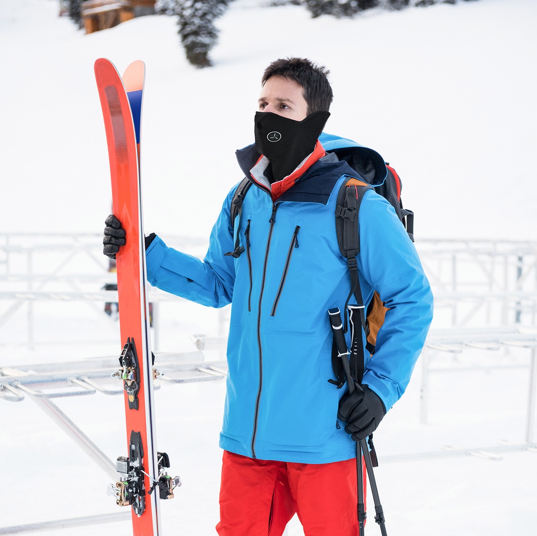 Skier standing with ski on snow covered mountains