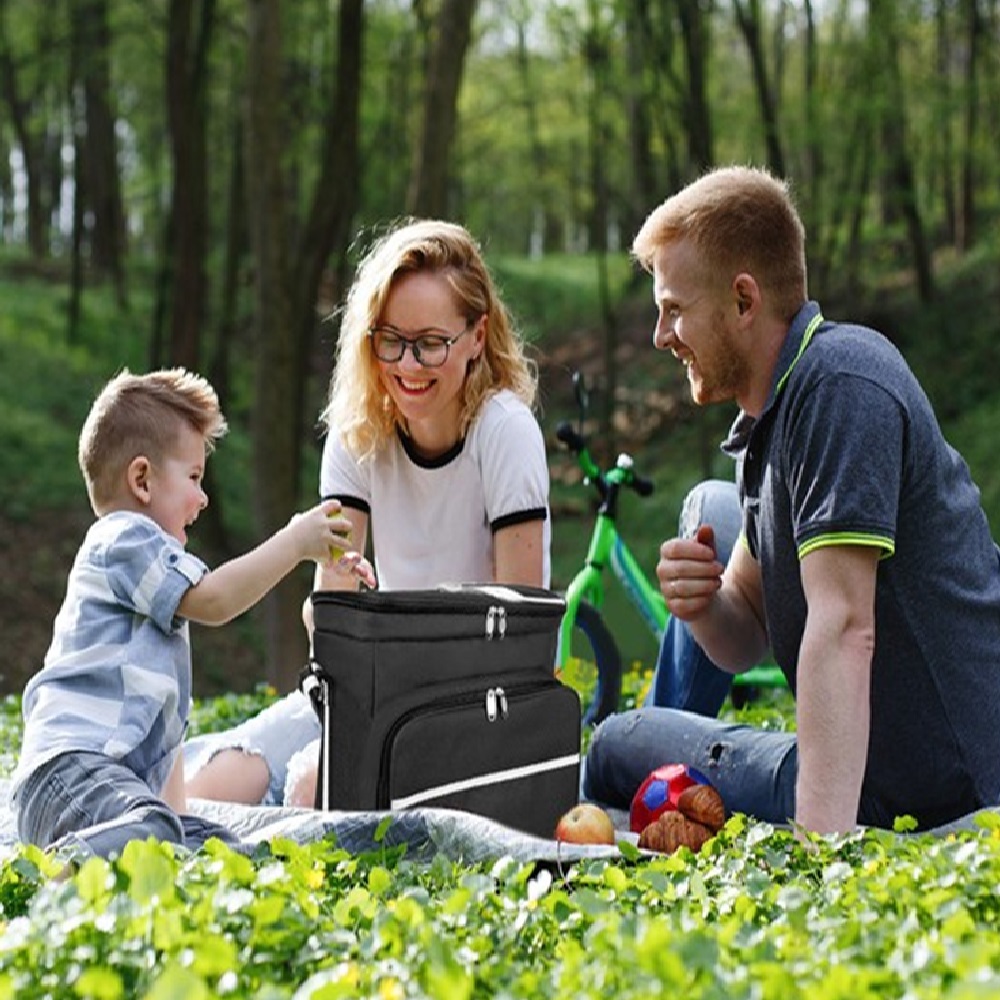 Mom, dad and a little boy taste apples sitting on the green gras